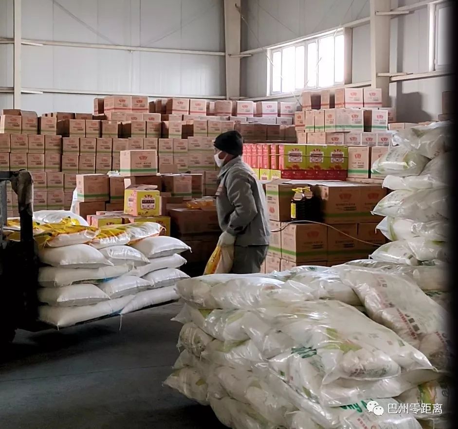 1月30日,新疆中聚粮油有限公司仓库内,工人正在往叉车上装面粉和大米